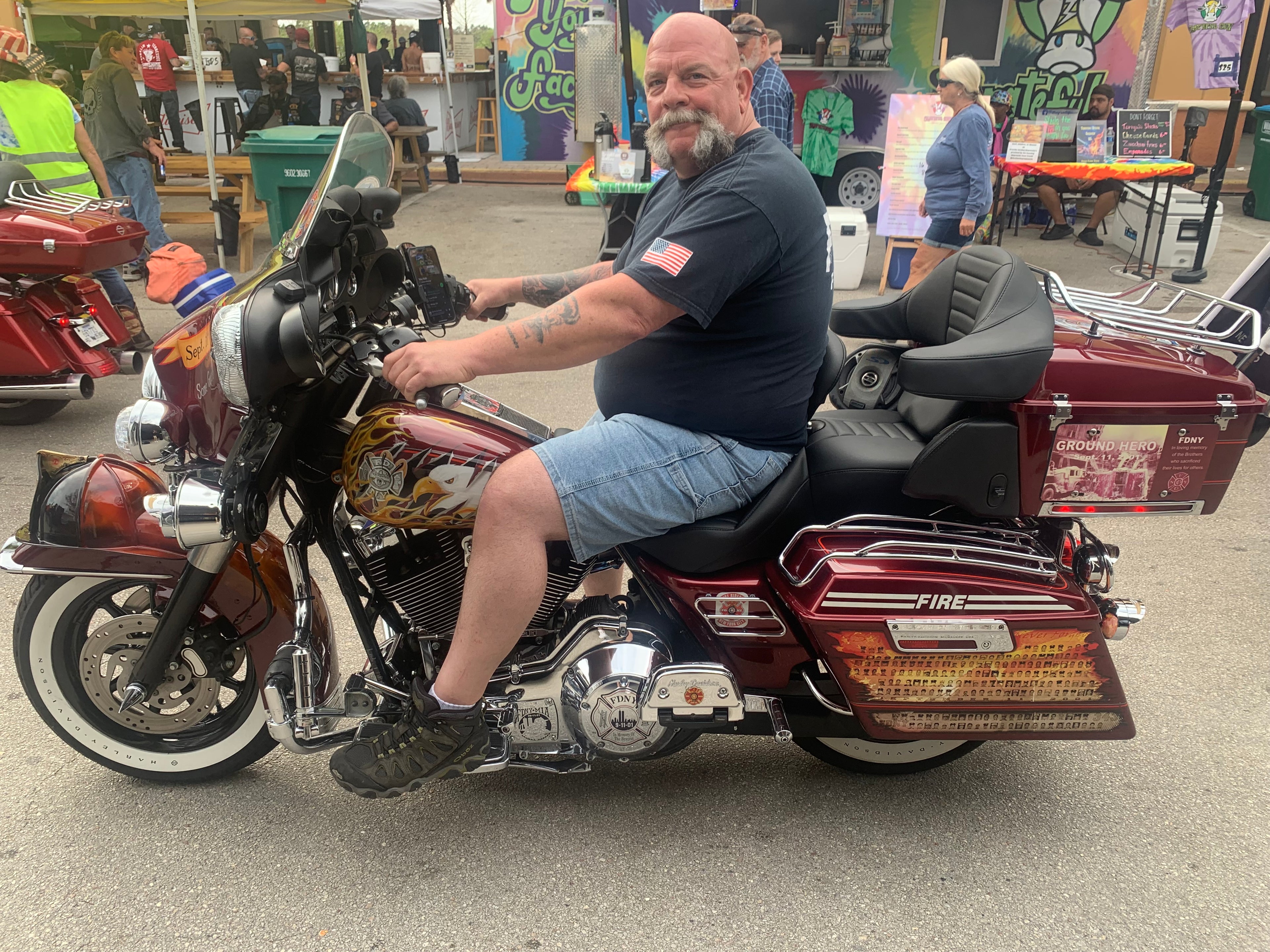 Man sitting on custom fire red motorcycle