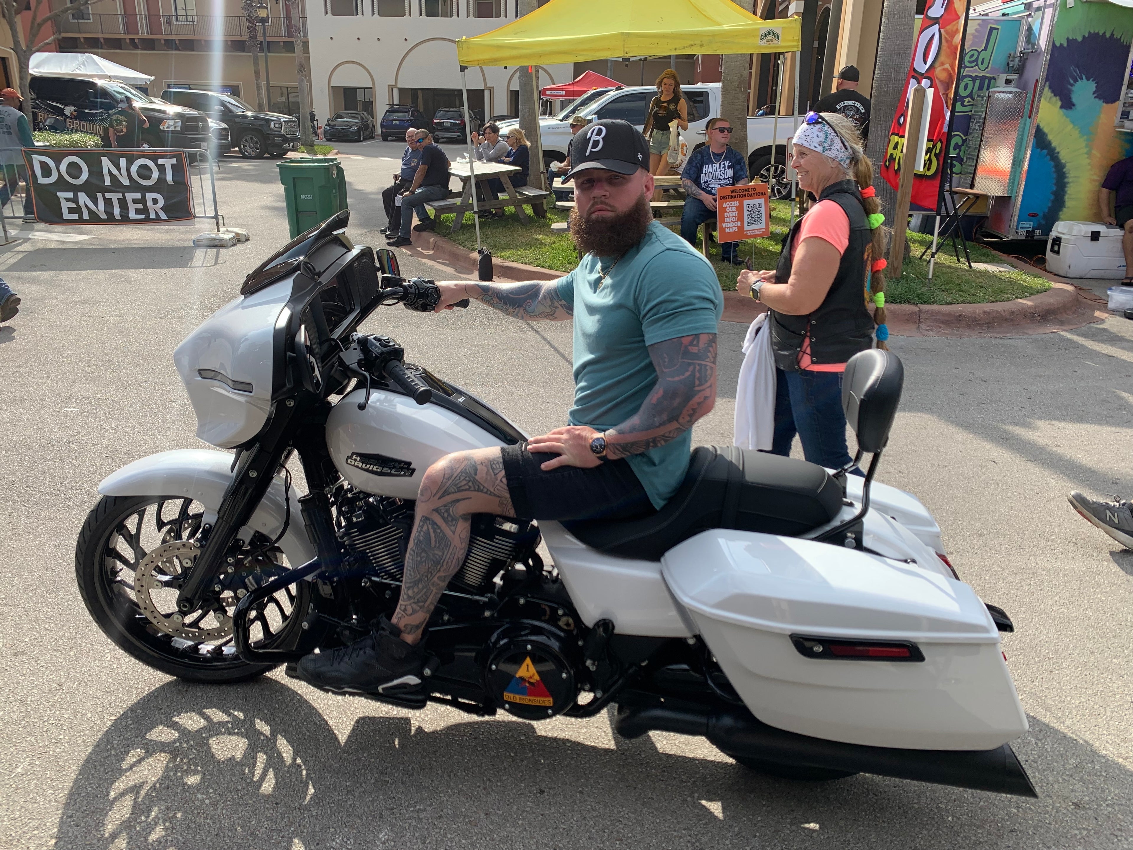 man in a blue shirt sitting on a white custom motorcycle