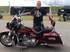 man standing in front of black and red motorcycle